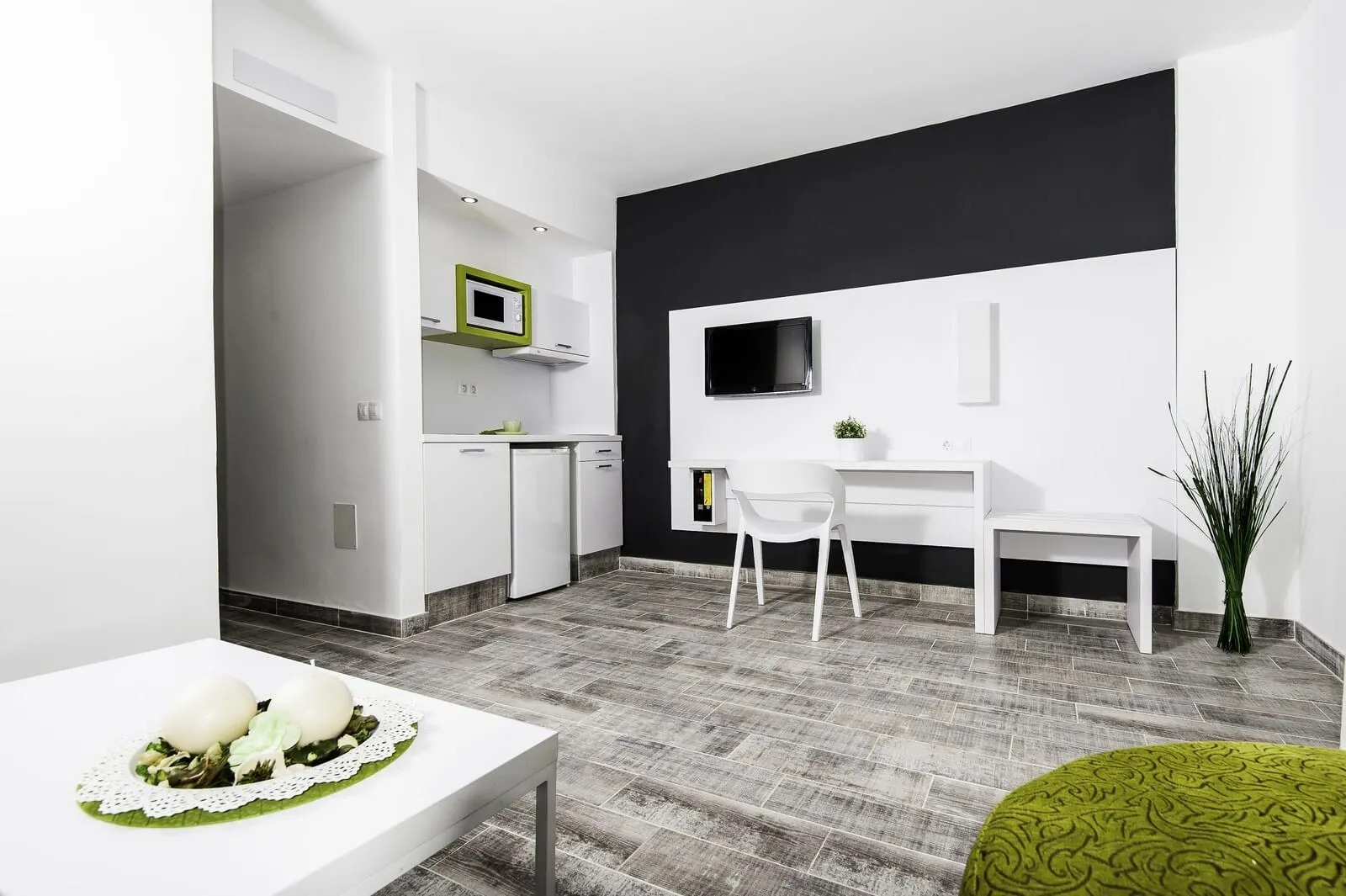 KN Aparthotel Columbus: A modern kitchen with white cabinets, a microwave, and a small island