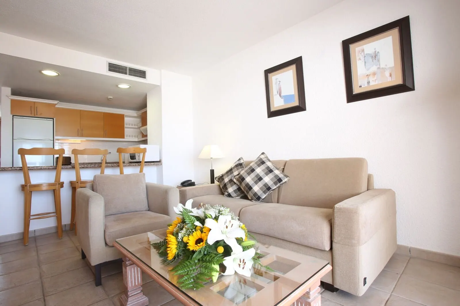Ona Beverly Hills Suites: A living room with a sofa, a coffee table with a floral arrangement