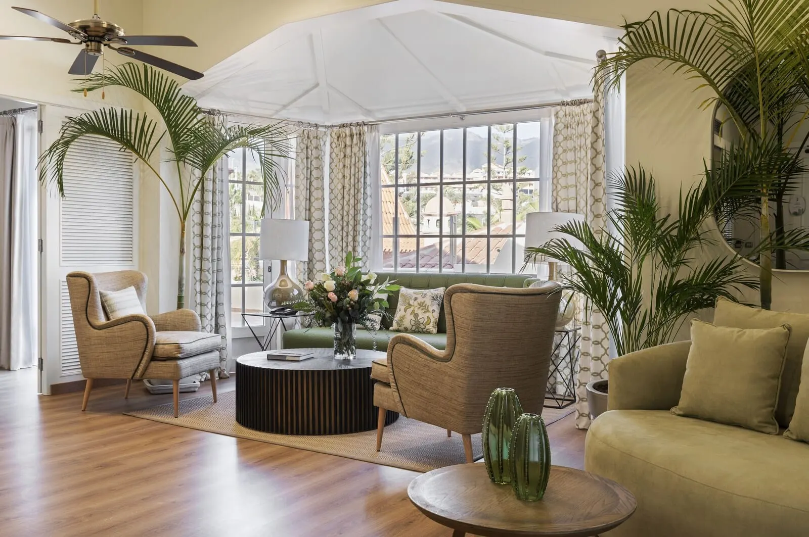 Bahía del Duque: A spacious living room with a large window, a ceiling fan
