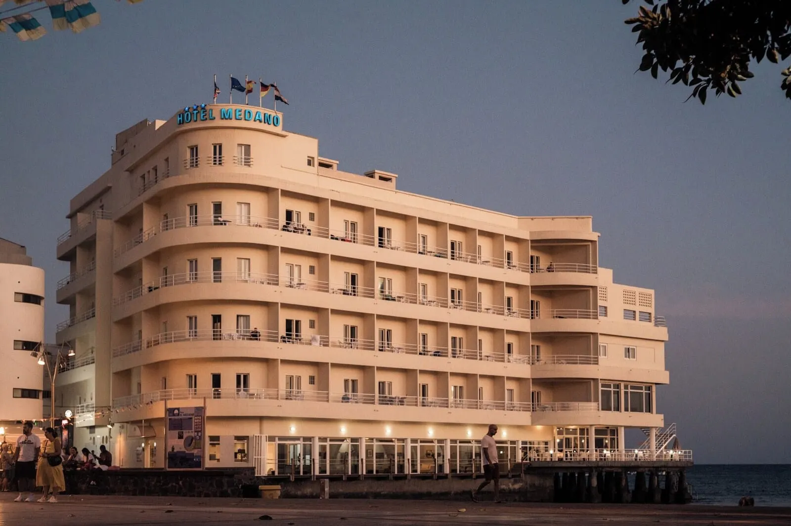 Médano Hotel: A multi-story hotel with balconies and a waterfront view
