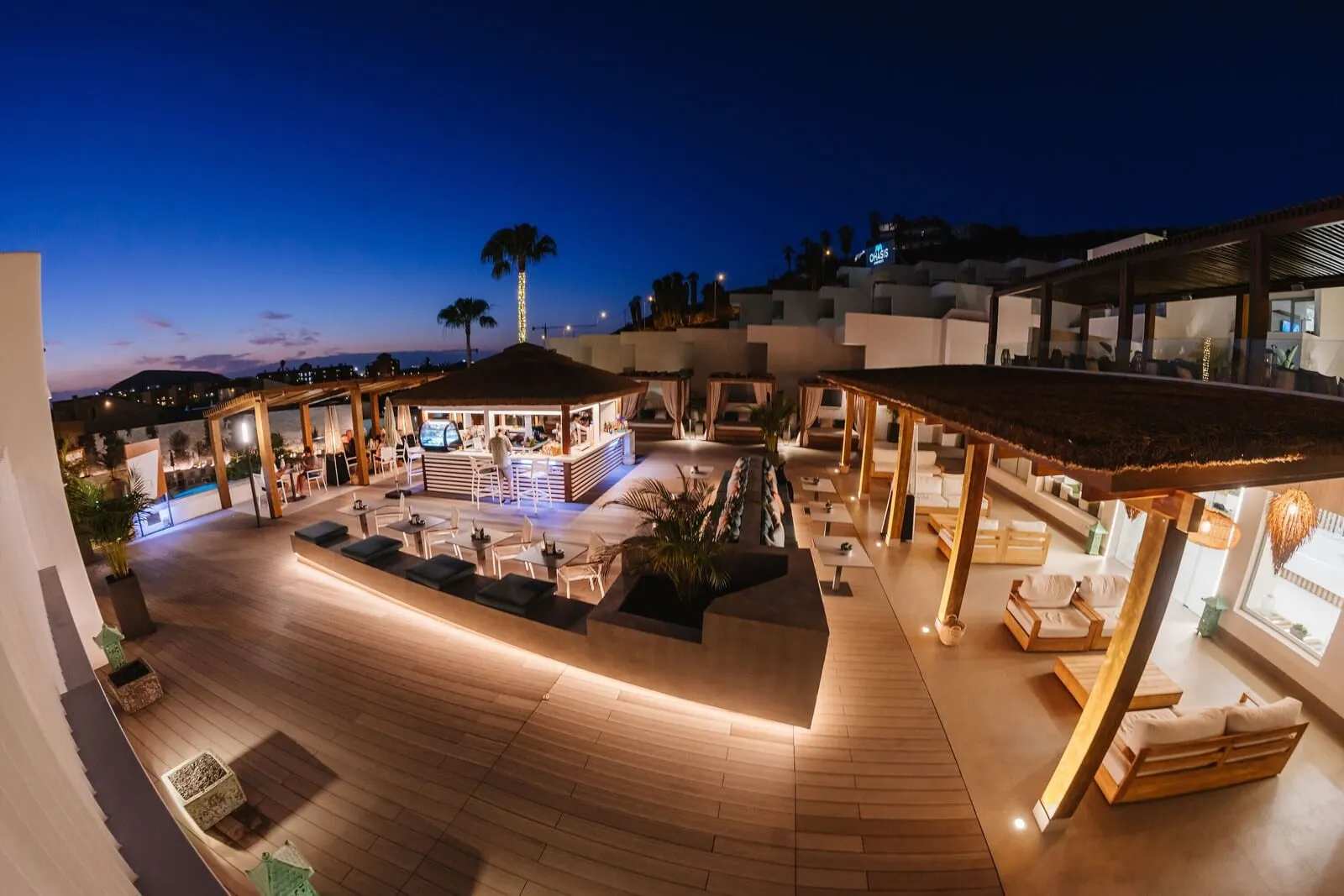 Ohasis Boutique Suites: A modern outdoor lounge area with wooden flooring, seating arrangements