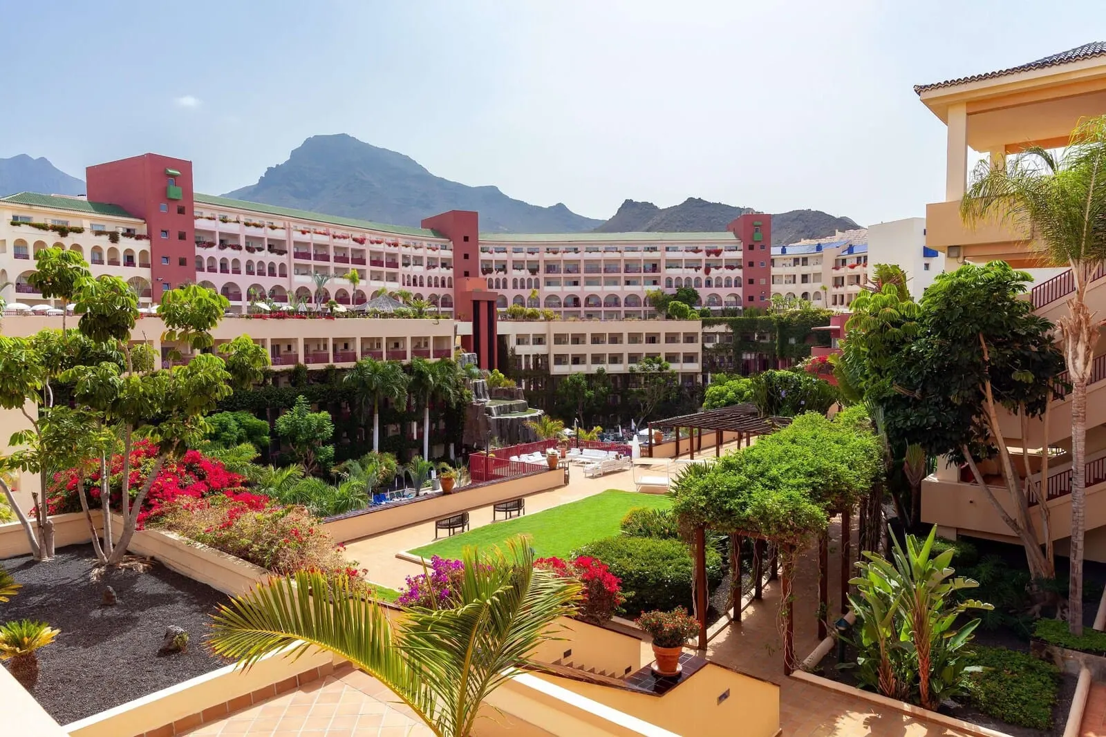 Best Jacaranda: A hotel courtyard with a pool, lush greenery, and a view of mountains