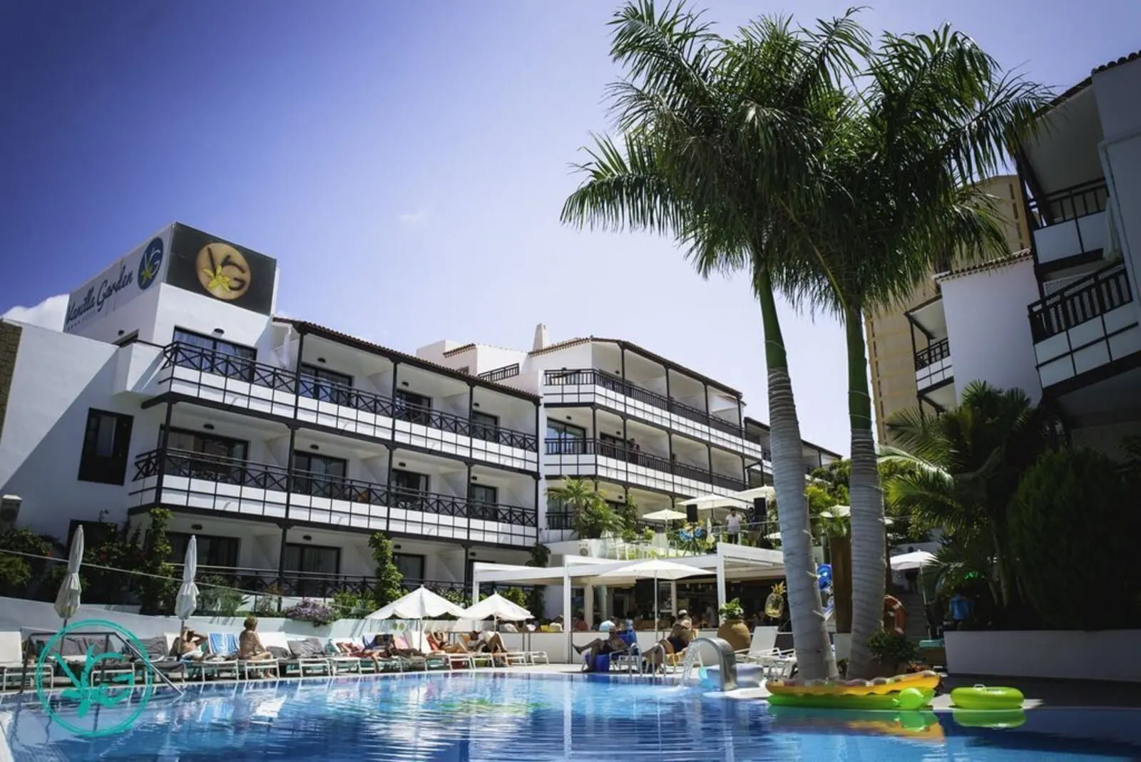 Vanilla Garden Boutique Hotel: A hotel with a pool area, multiple balconies, and palm trees