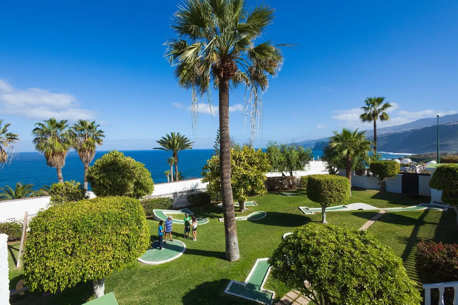 BLUESEA Interpalace: A well-maintained garden with palm trees and manicured lawns
