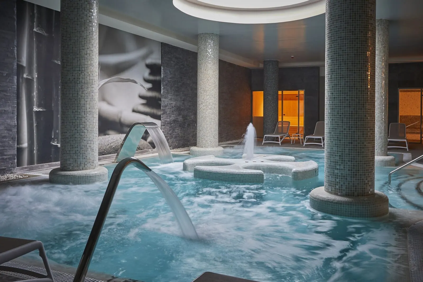 Bahia Principe Explore Fantasia: A spa area with a hot tub, seating, and a mural