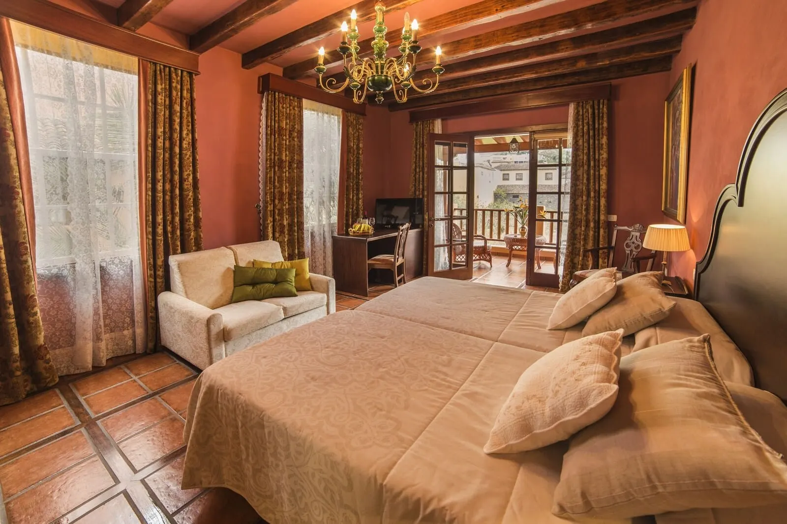 Hotel Emblemático San Marcos: A hotel room with a large bed, a sofa, a TV, and a balcony with a view