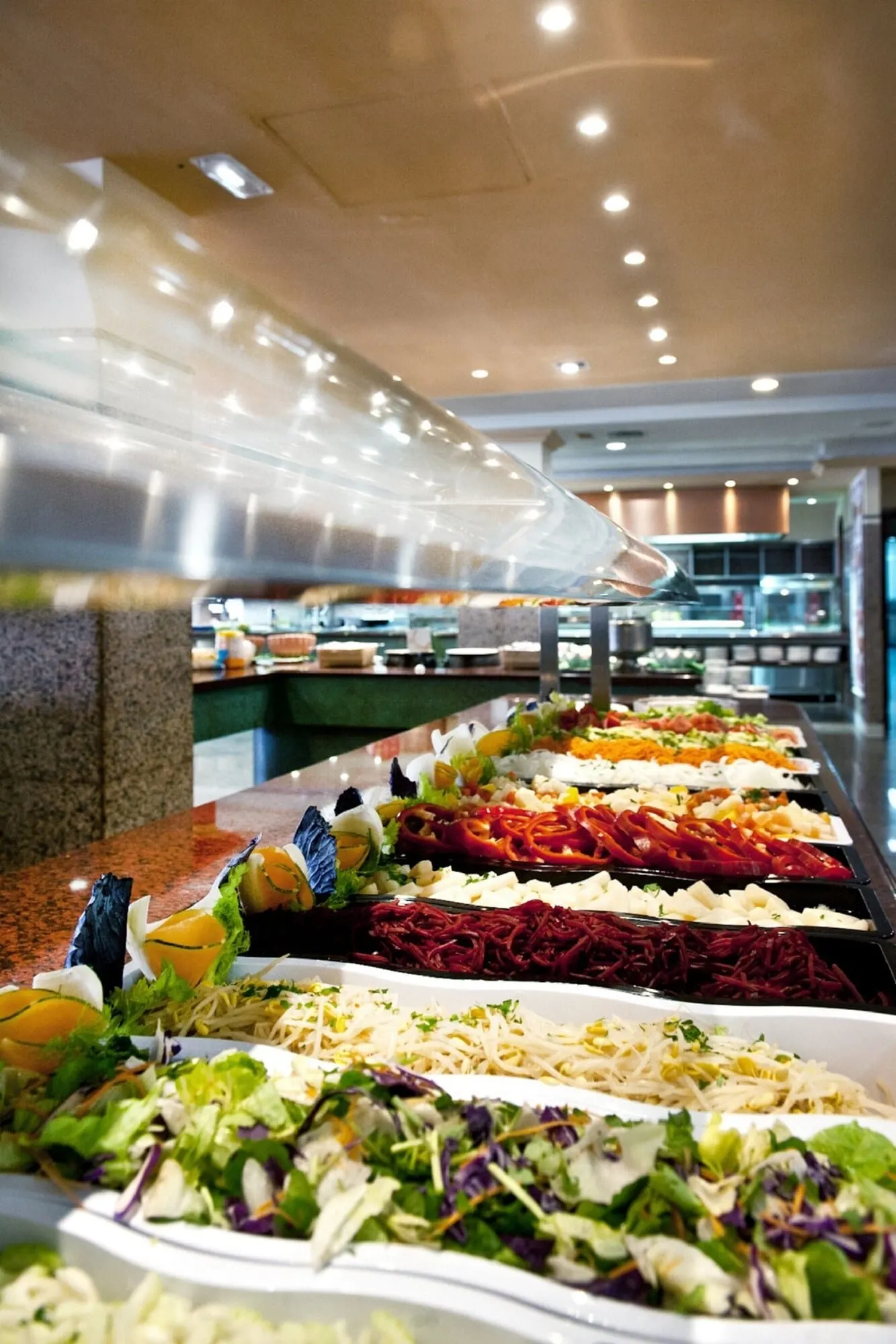 Spring Hotel Bitácora: A buffet with various food options including salads, meats, and cheeses