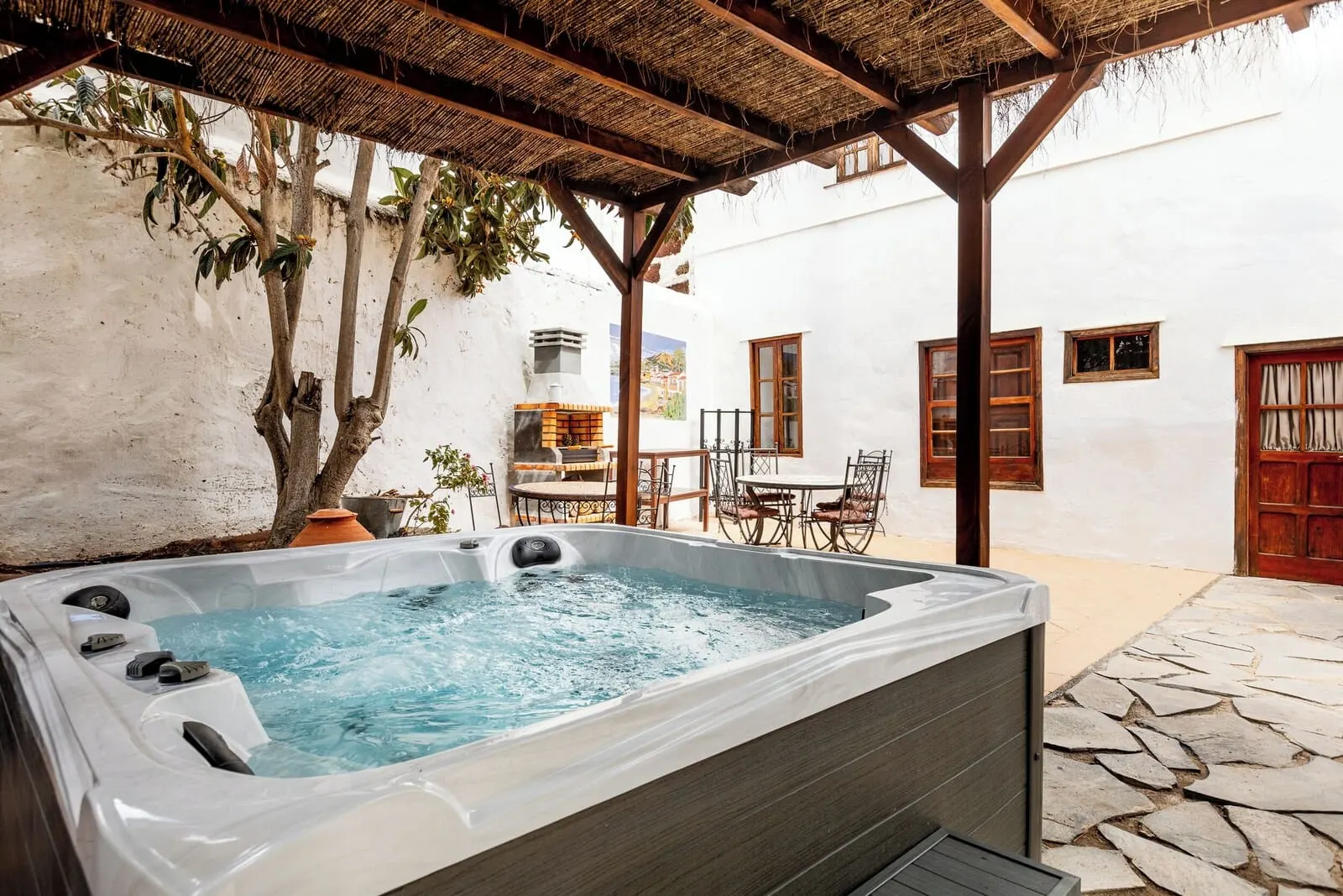 Hotel Duque de la Torre: A hot tub under a wooden pergola, white walls, and a stone patio