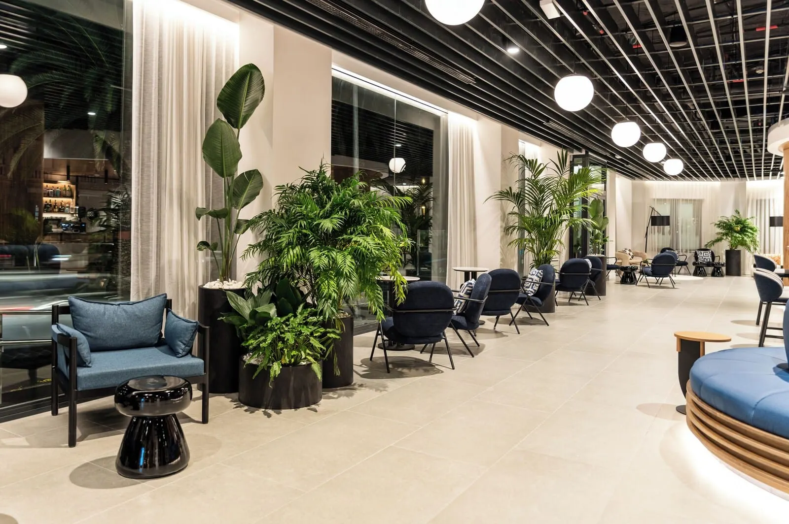 Barceló Santa Cruz Contemporáneo: A modern lounge area with seating, potted plants, and a glass wall