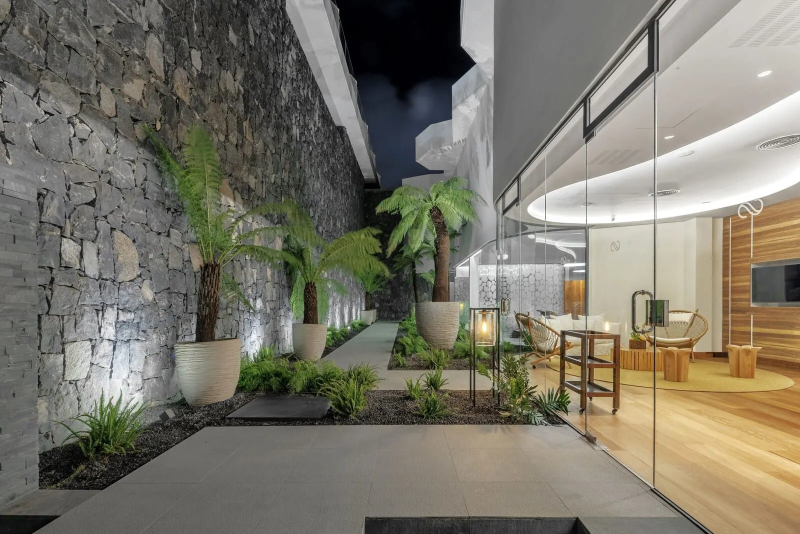 Royal Hideaway Corales Suites: A modern indoor space with a stone wall, potted plants