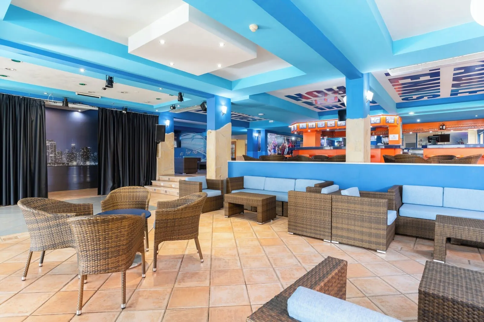 HOVIMA Jardín Caleta: A modern lounge area with wicker furniture, a bar, and a cityscape view