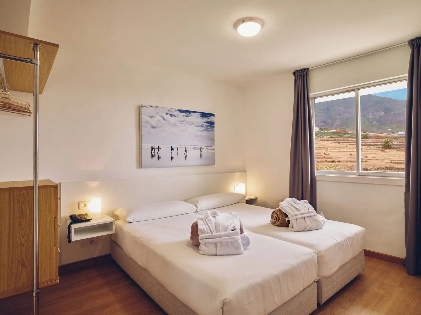 Route Active Hotel: A hotel room with two beds, a painting of people on a beach