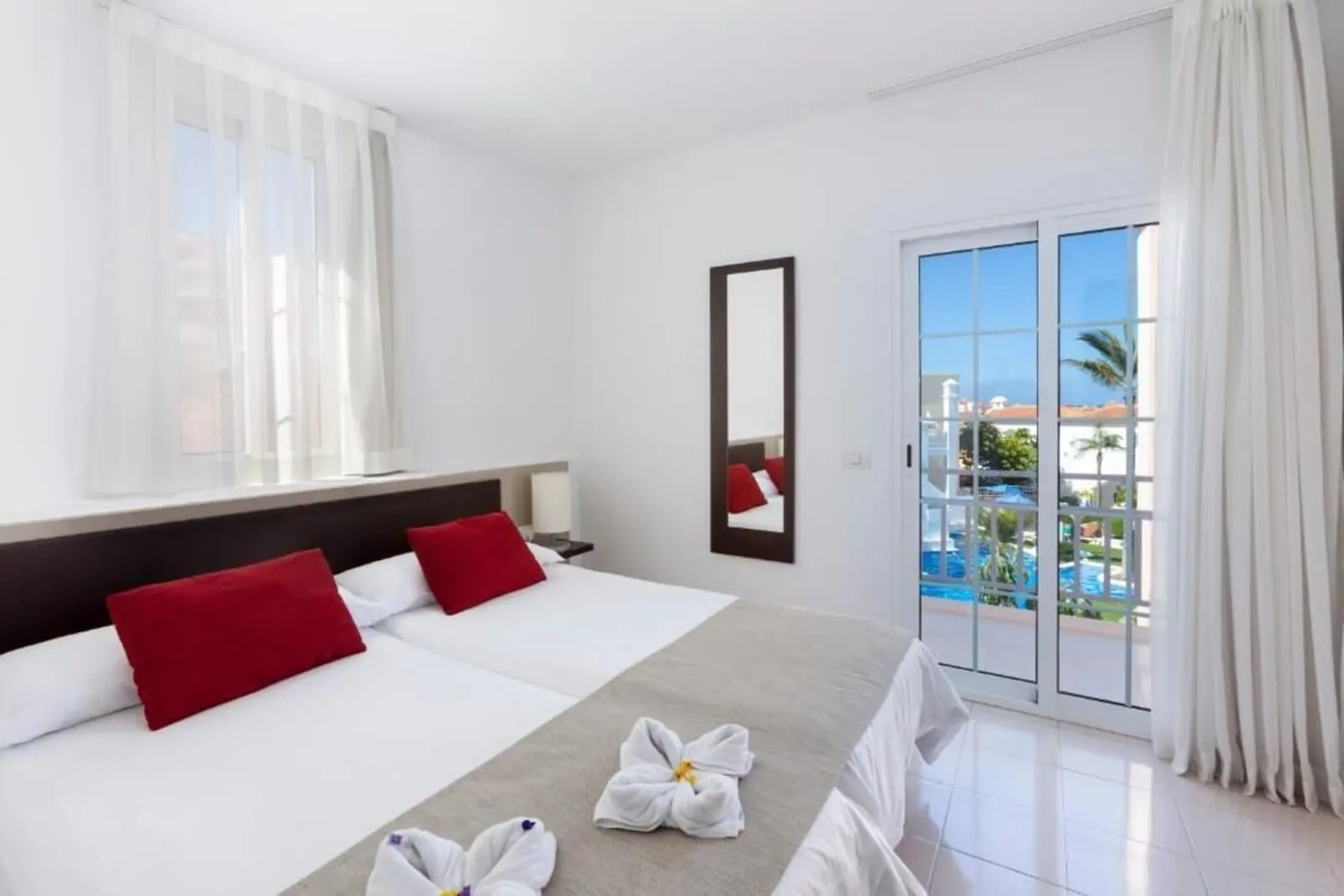 BLUESEA Bahía Fañabé Villas: A hotel room with two beds, a large window, a sliding glass door to a pool