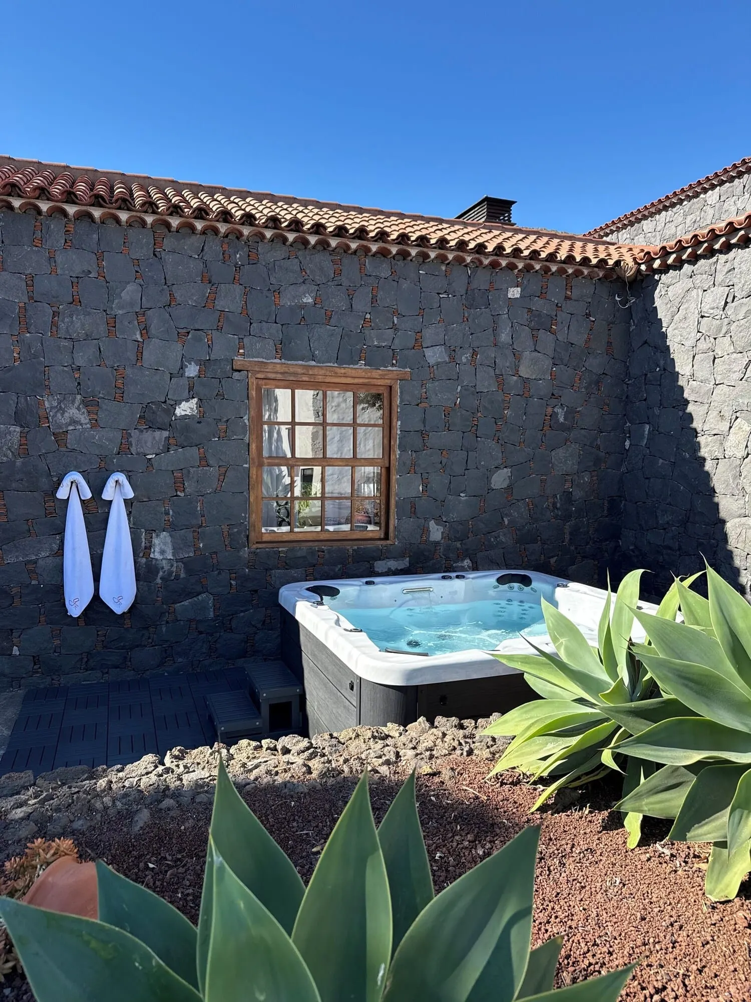 Hotel La Casona del Patio: A stone-walled outdoor area with a hot tub, a window