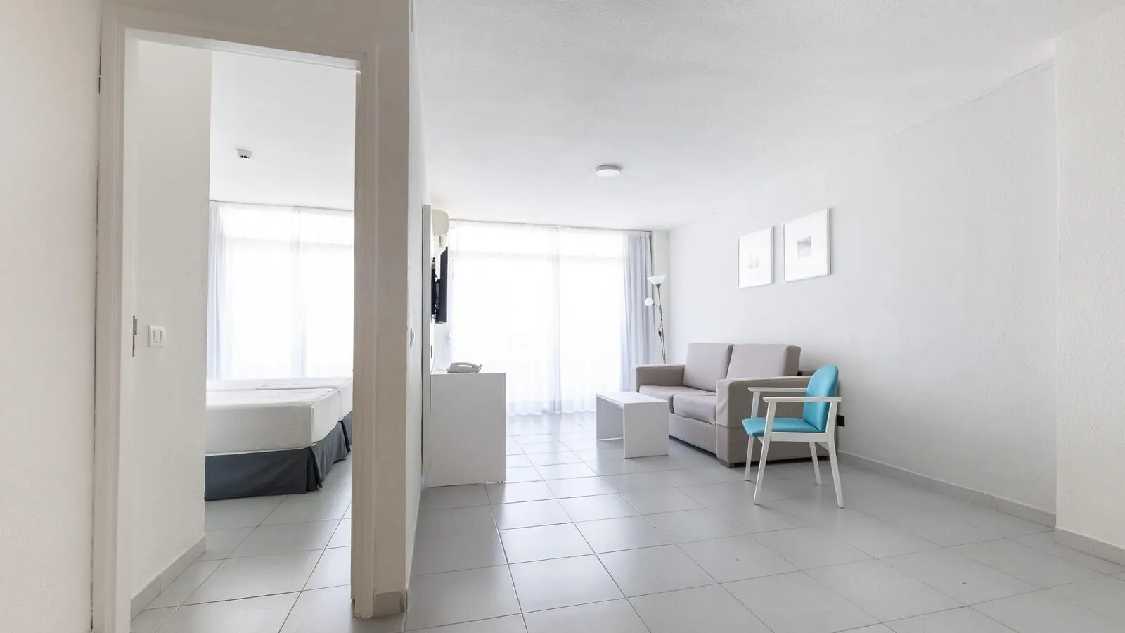 BlueSea Lagos de César: A modern, well-lit living room with a sofa, a small table, and a blue chair