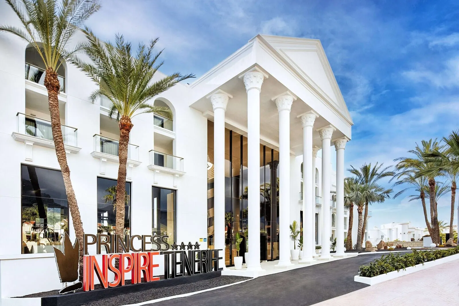 Princess Inspire Tenerife: A hotel with a classical facade, palm trees, and a clear sky