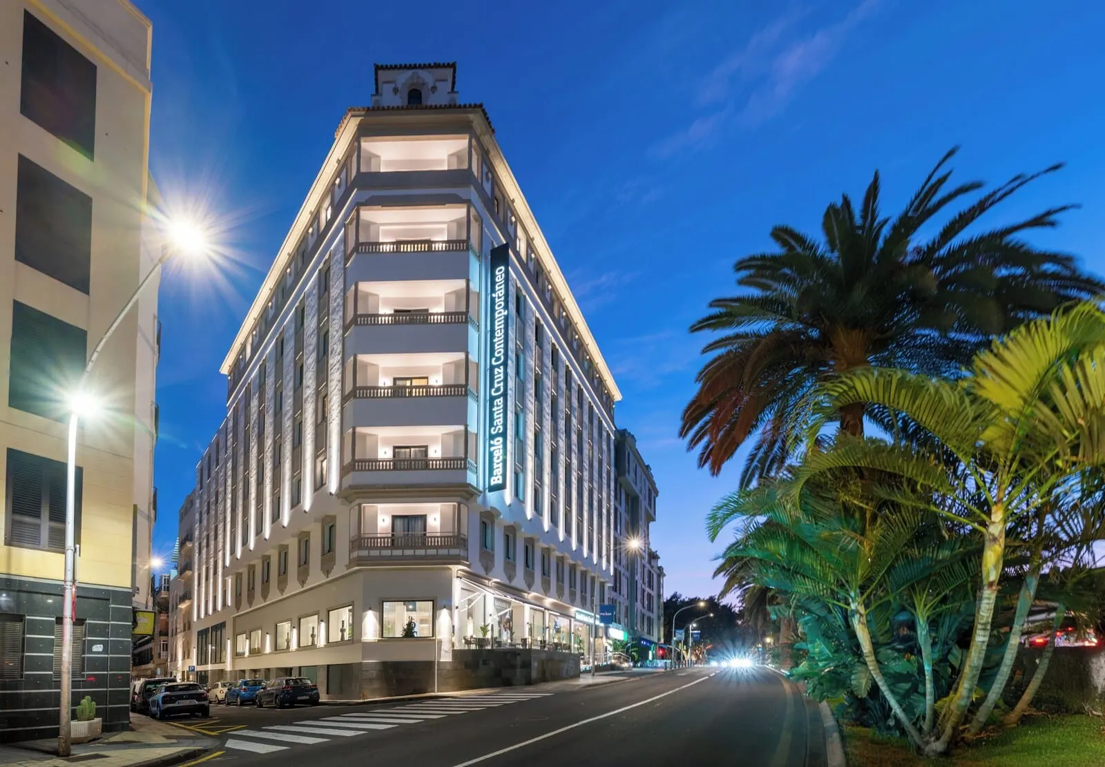 Barceló Santa Cruz Contemporáneo: A multi-story hotel with balconies, a street view, and palm trees