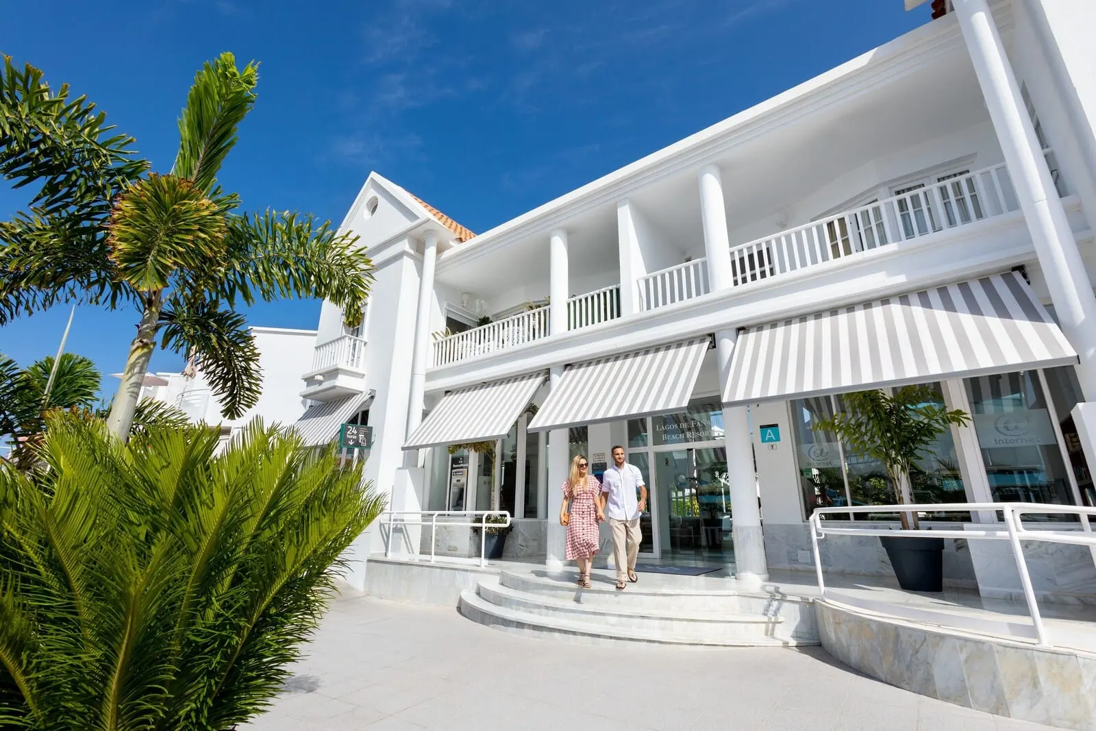 Lagos de Fañabé Beach Resort: A white building with a balcony and a potted plant