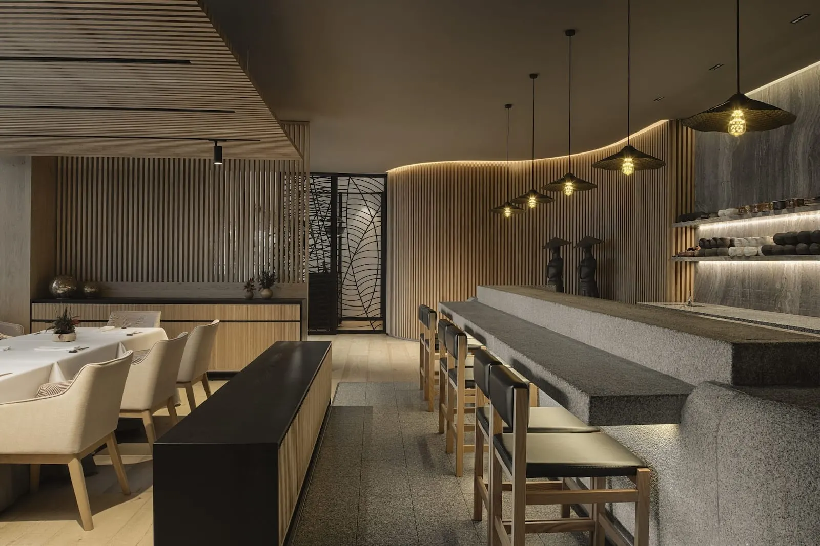Royal Hideaway Corales Beach: A modern restaurant with a long counter, wooden chairs, and pendant lighting