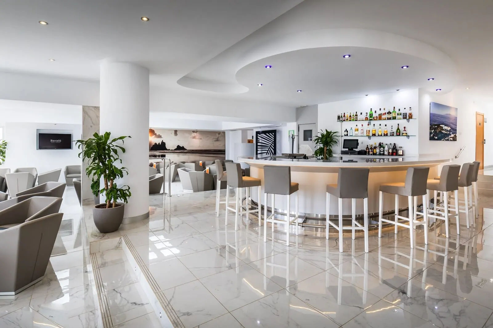 Barceló Santiago: A modern hotel lobby with a bar area, seating, and a large potted plant