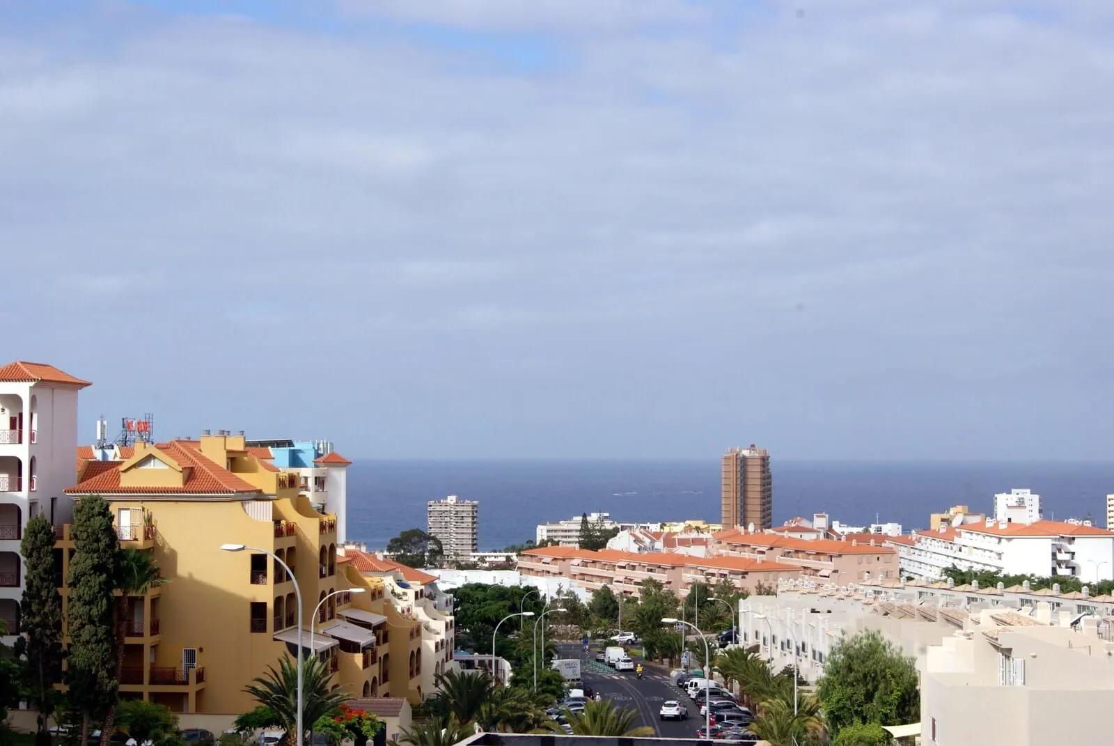Ohasis Boutique Suites: A coastal cityscape with buildings, a road, and the sea in the background