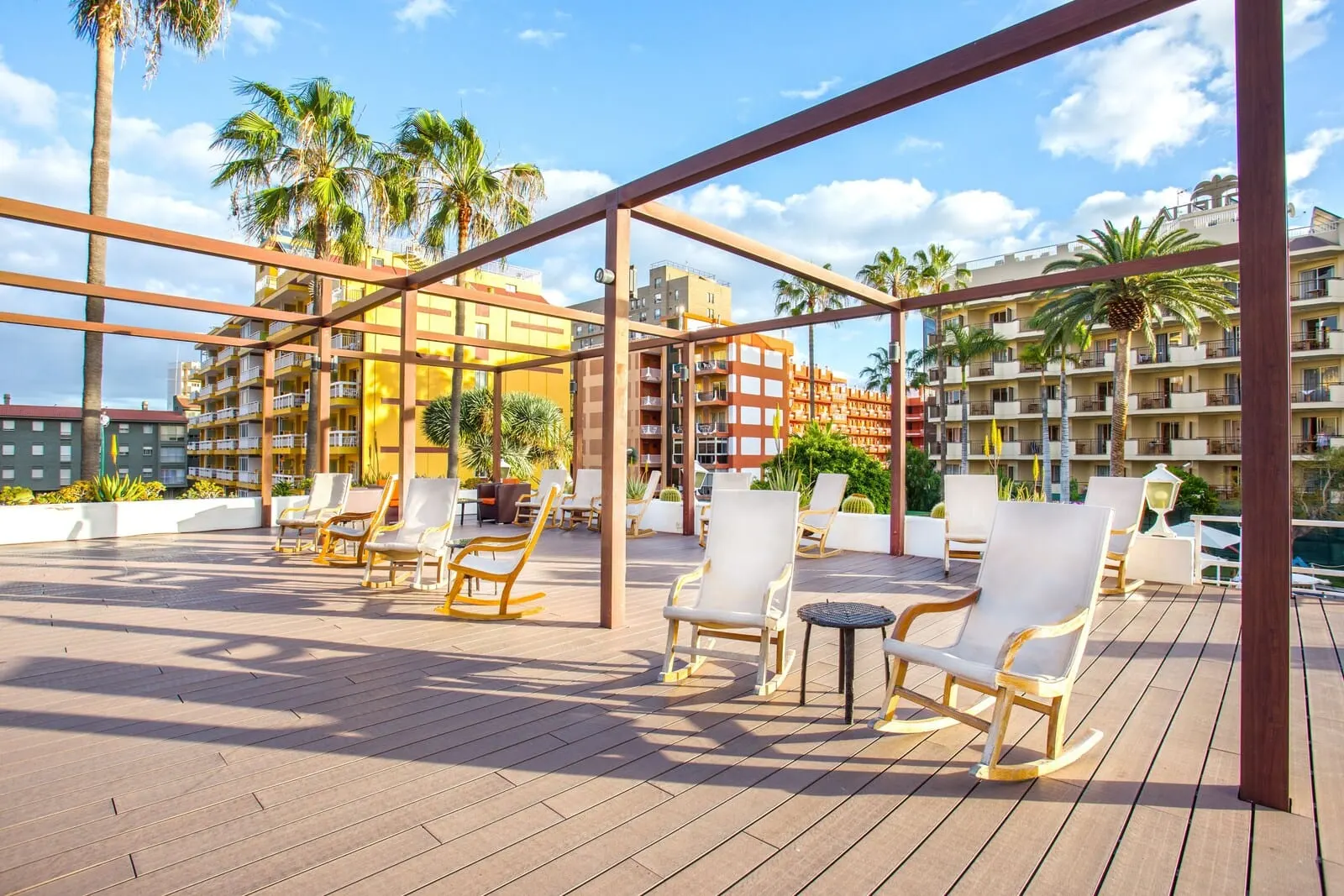 Be Live Adults Only Tenerife: A rooftop lounge with outdoor seating and a view of a hotel building