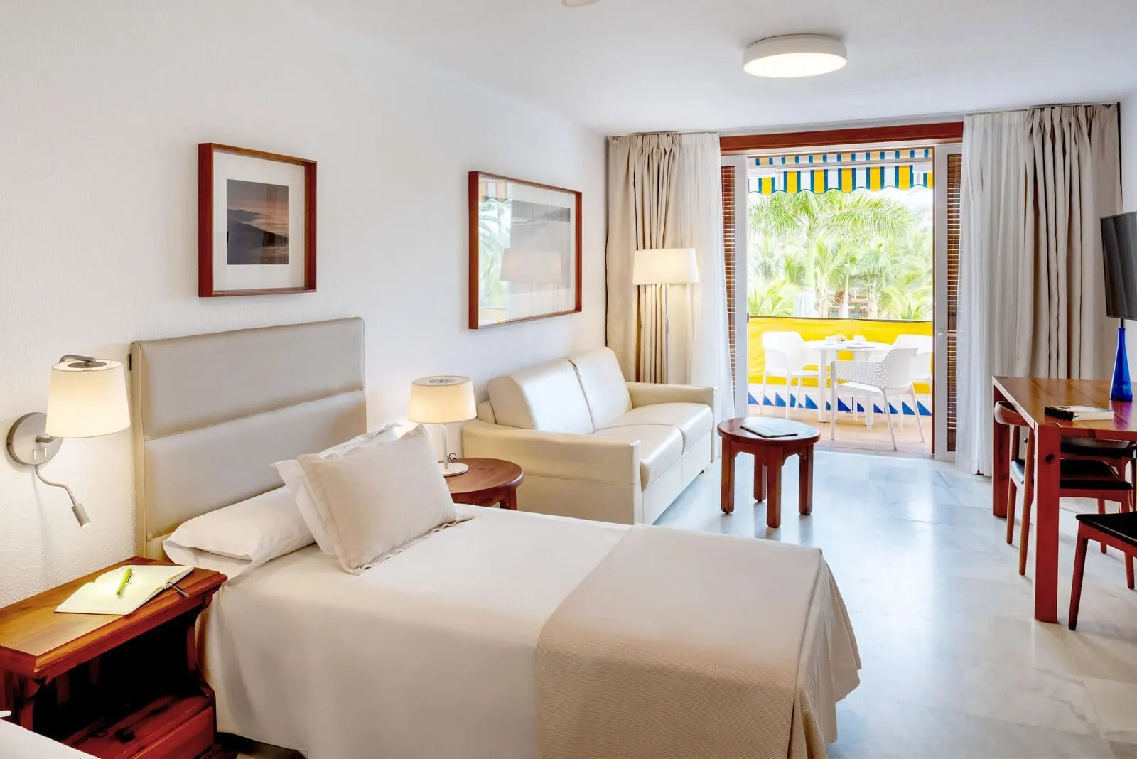 Parque Santiago III: A hotel room with a bed, a sofa, a desk, and a TV