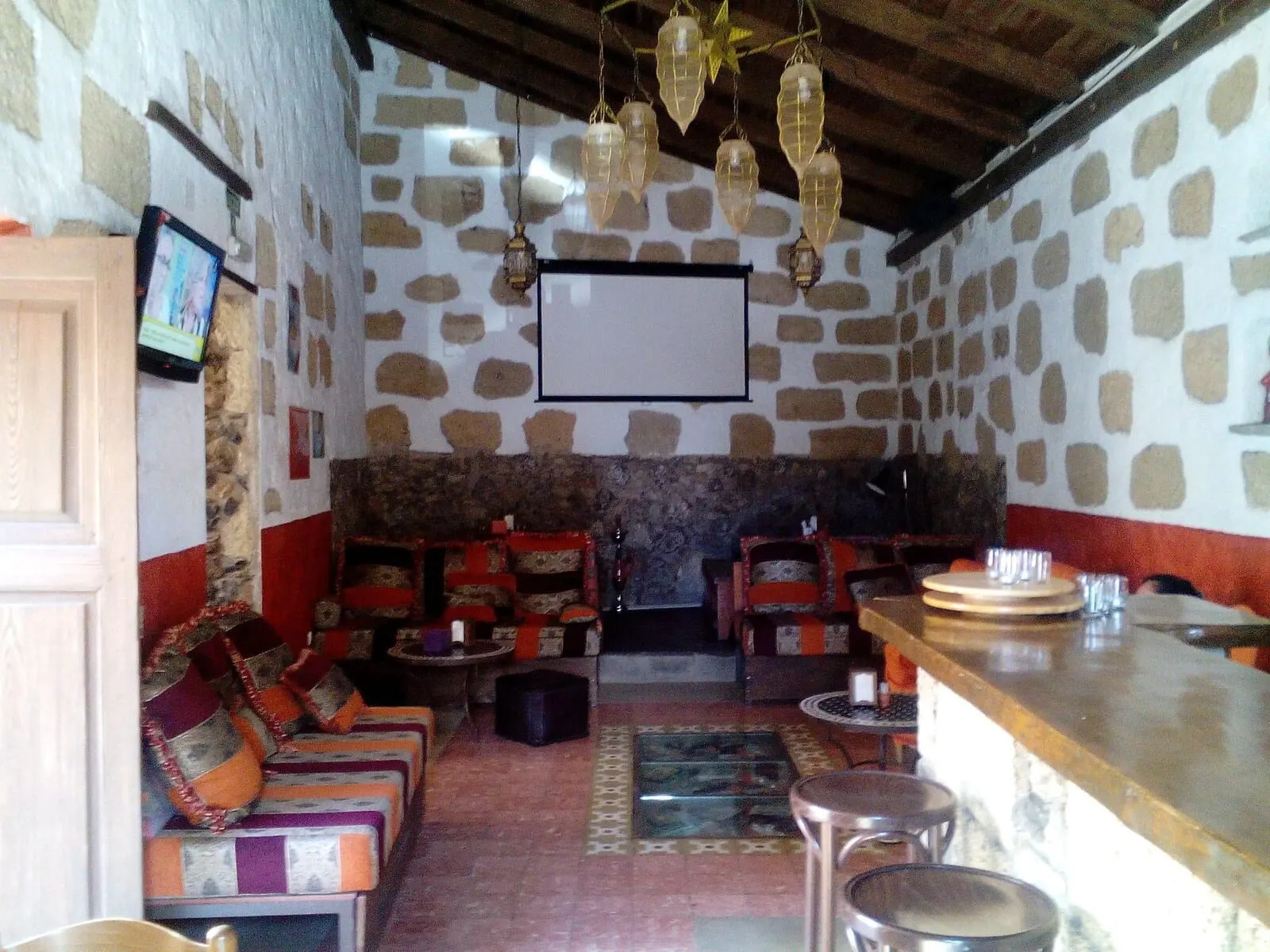 Hotel Cuatro Esquinas: A cozy interior with stone walls, a fireplace, and a bar area
