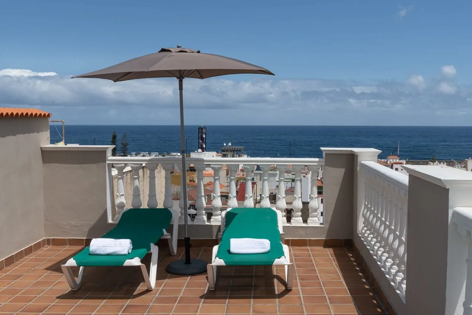 Hotel Marte: A balcony with two sun loungers, a table, and an umbrella, overlooking the sea