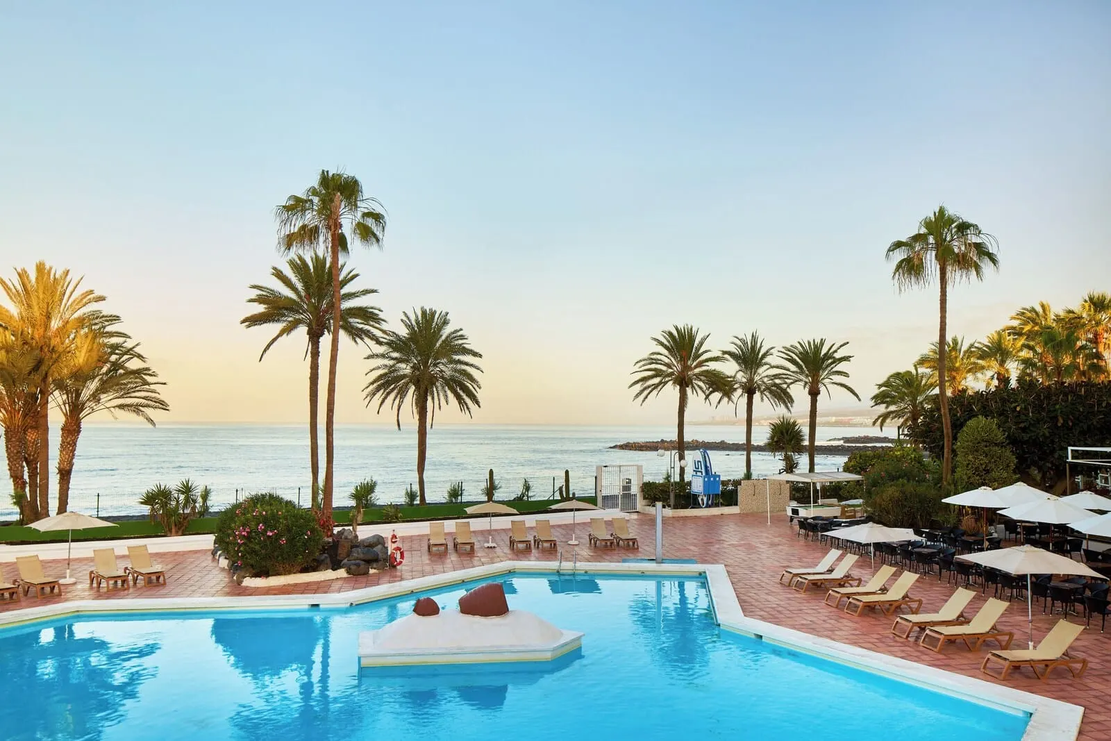 Sol Tenerife: A pool area with lounge chairs and umbrellas