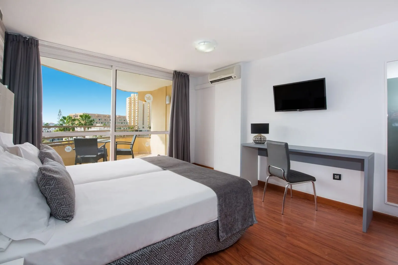 Olé Tropical Tenerife: A hotel room with a large bed, a desk, a chair, a TV