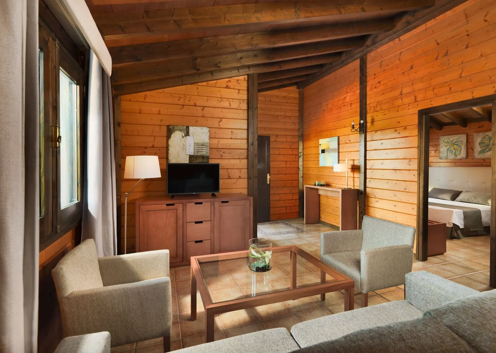 Hotel Rural Finca Salamanca: A cozy log cabin interior with a sofa, a glass-top coffee table