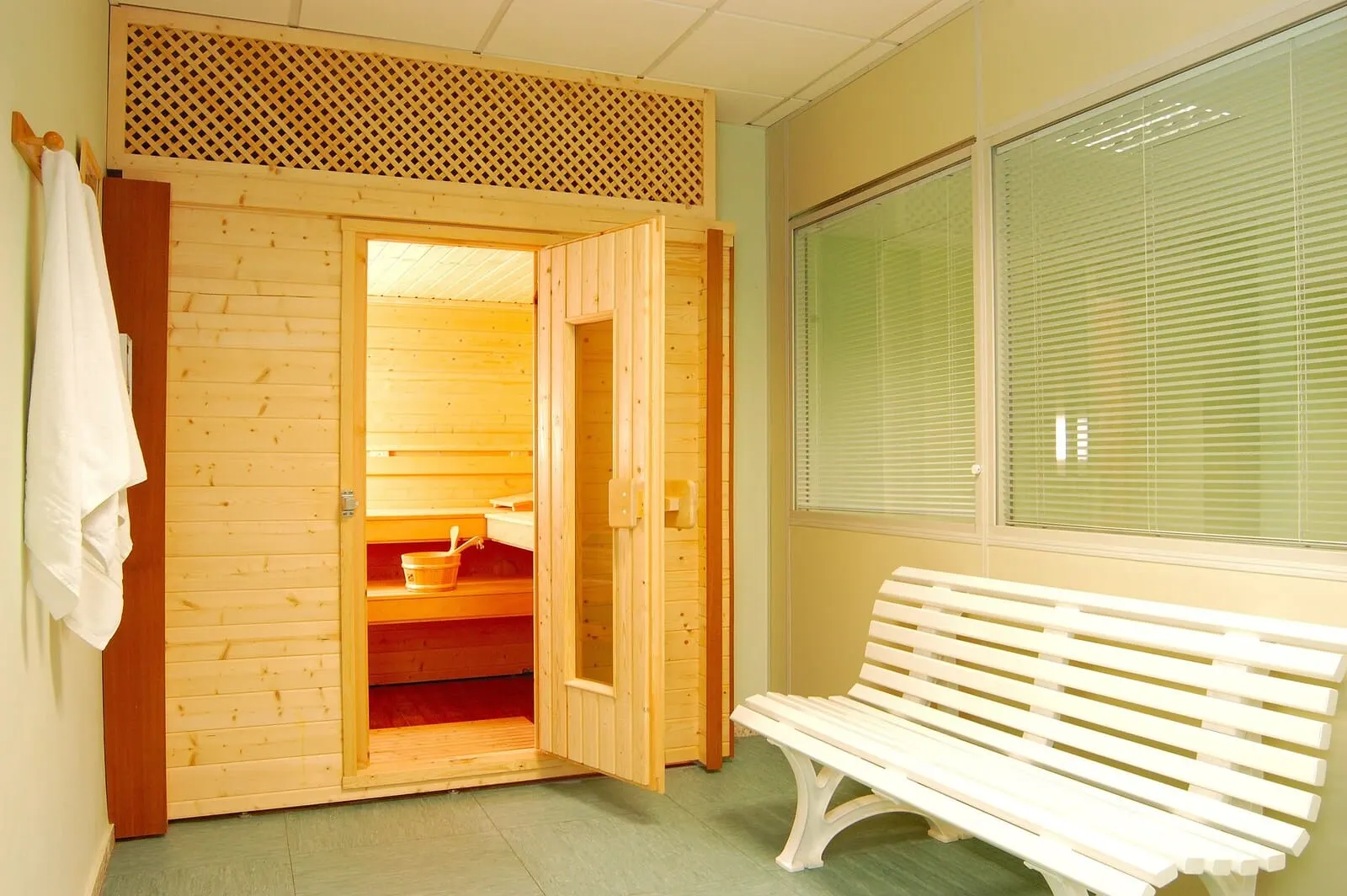 Hotel Don Manolito: A wooden sauna room with benches, a bench outside, and a window with blinds