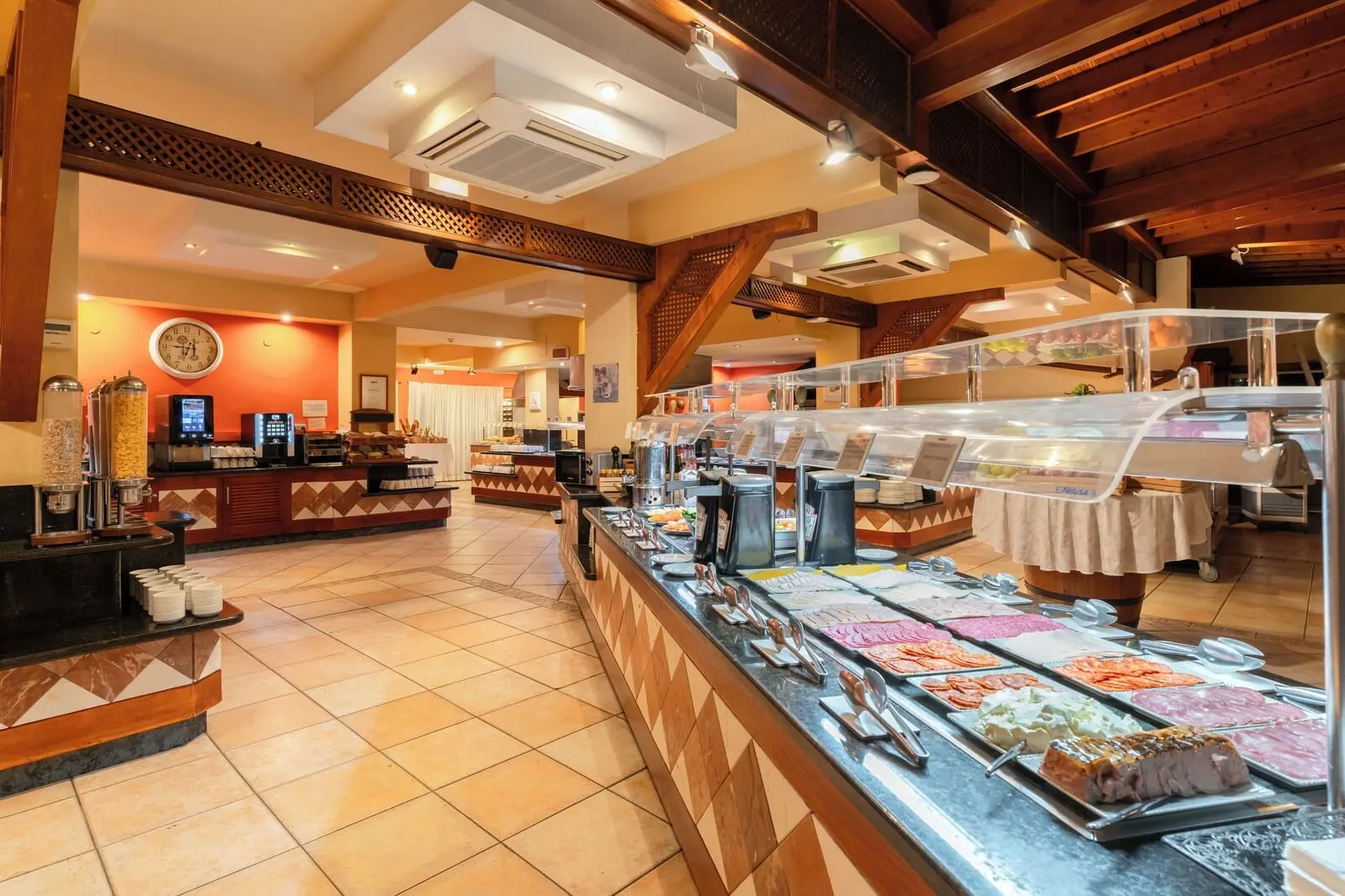 HOVIMA Jardín Caleta: A buffet area with a variety of food options, a coffee station, and a clock on the wall