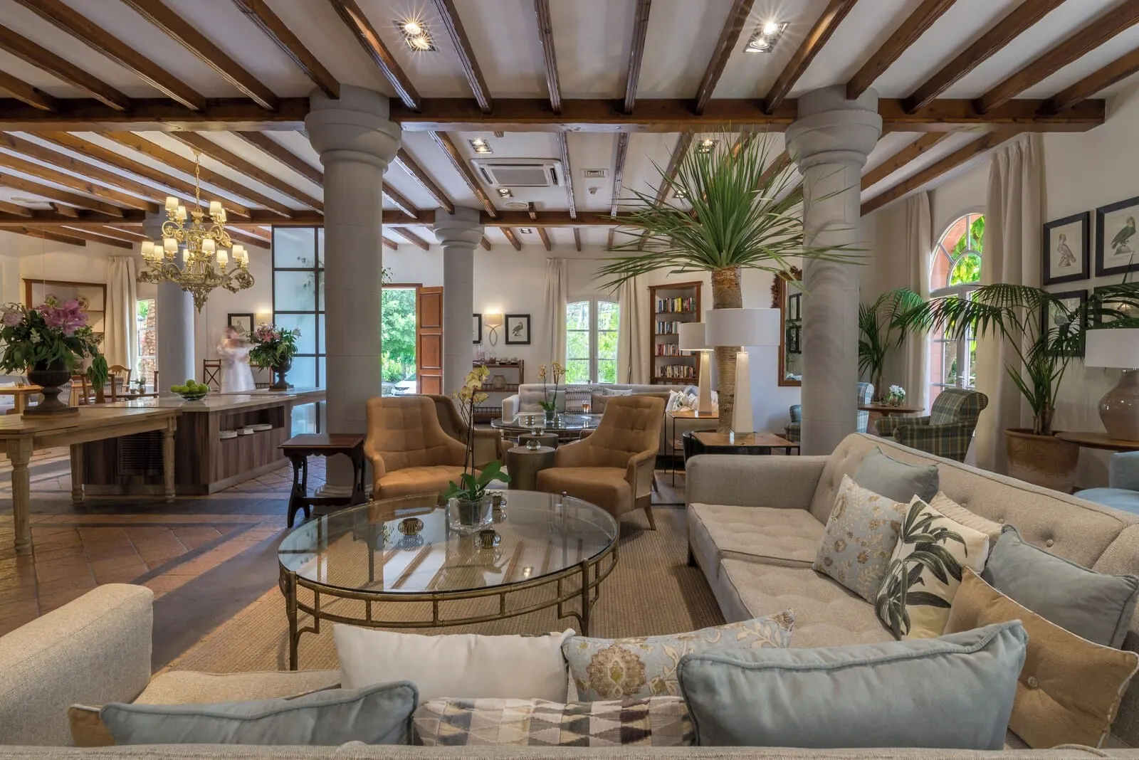Bahía del Duque: A spacious living room with a glass coffee table, comfortable sofas, and a large plant