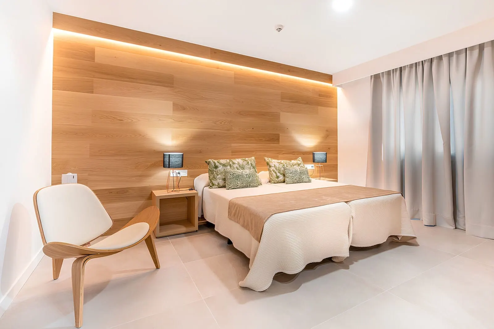 Ohasis Boutique Suites: A modern bedroom with a wooden headboard, a bed with a beige blanket