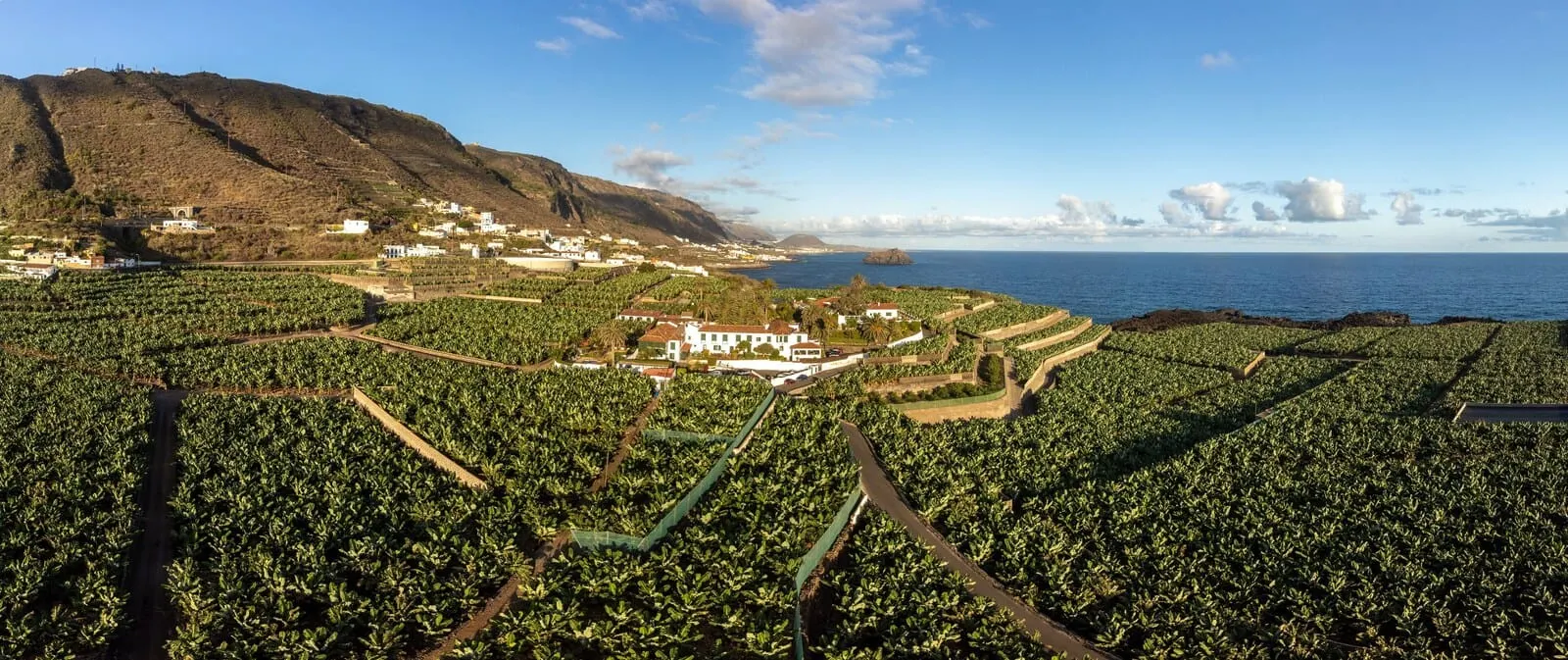Hotel El Patio: A coastal town with vineyards and a prominent white building with a red roof