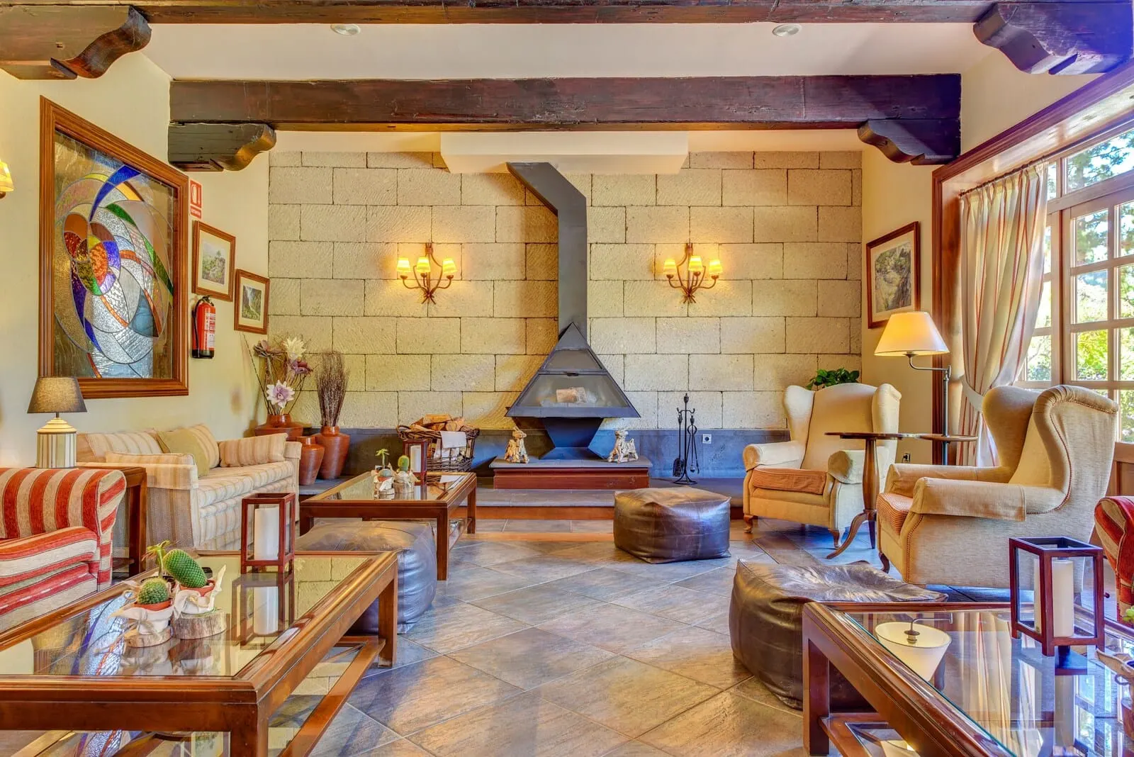 Hotel Spa Villalba: A cozy living room with a fireplace, comfortable seating, and decorative lighting