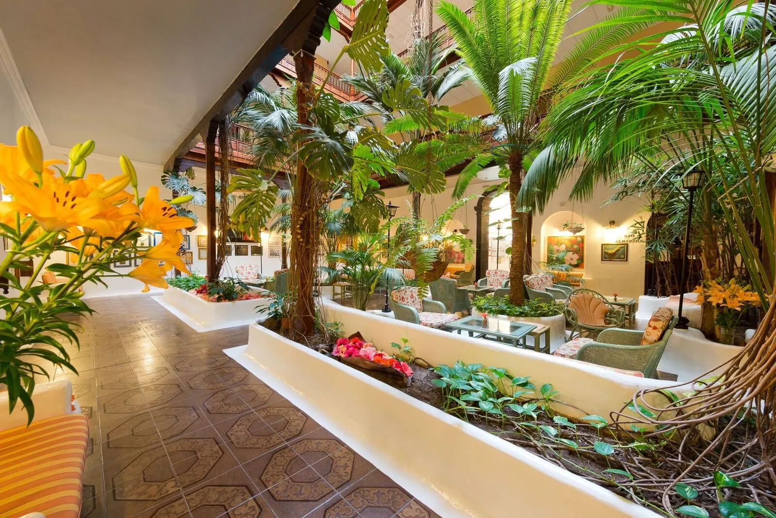 Hotel Monopol: A lush indoor garden with seating areas, large plants, and a variety of flowers