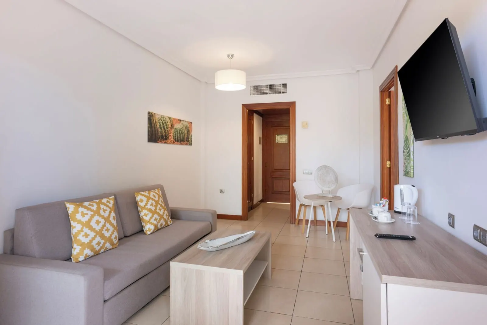Landmar Costa Los Gigantes: A modern living room with a sofa, coffee table, and a TV mounted on the wall
