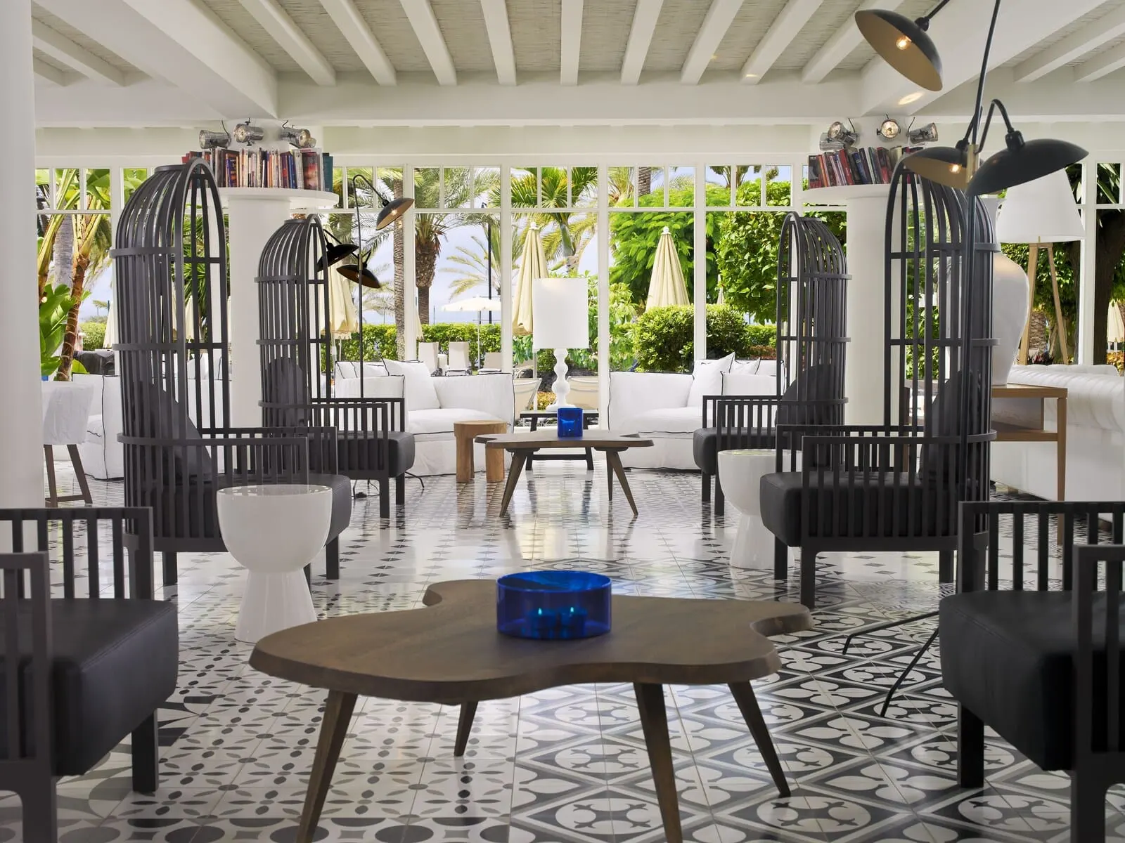 H10 Big Sur: A modern lounge area with a patterned floor, white sofas, black chairs