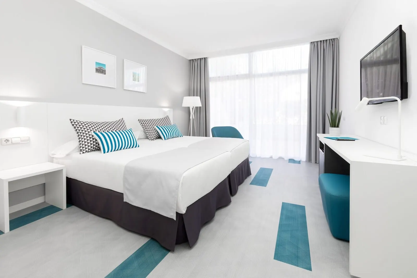 BLUESEA Interpalace: A modern hotel room with a large bed, a desk, and a TV