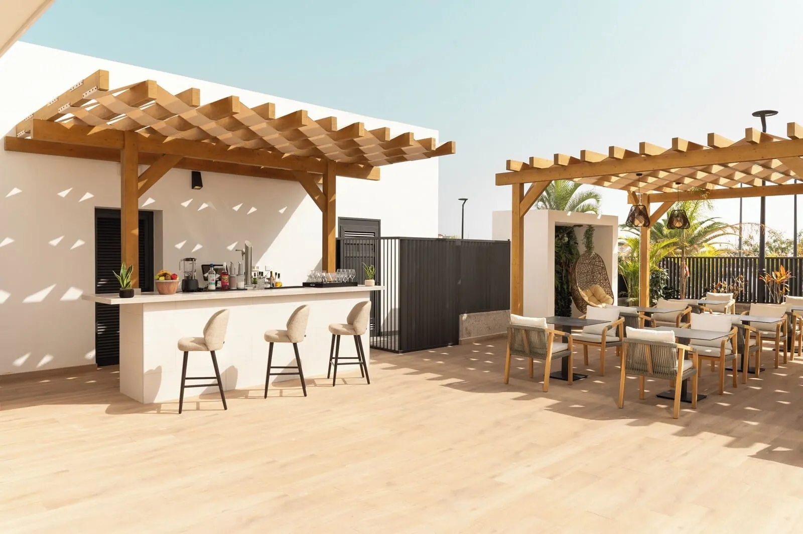 Amarilla Golf Residences: An outdoor patio area with a wooden pergola, a bar with stools