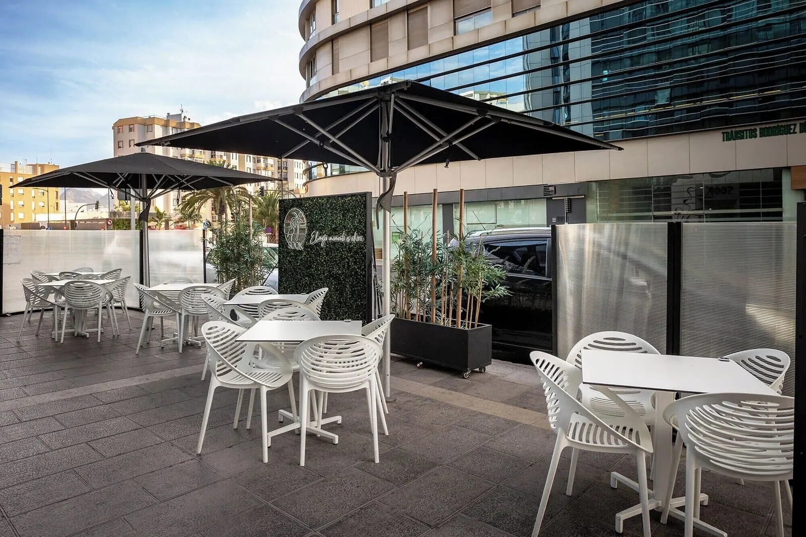 Eurostars Atlántida: An outdoor patio area with white plastic chairs and tables, umbrellas