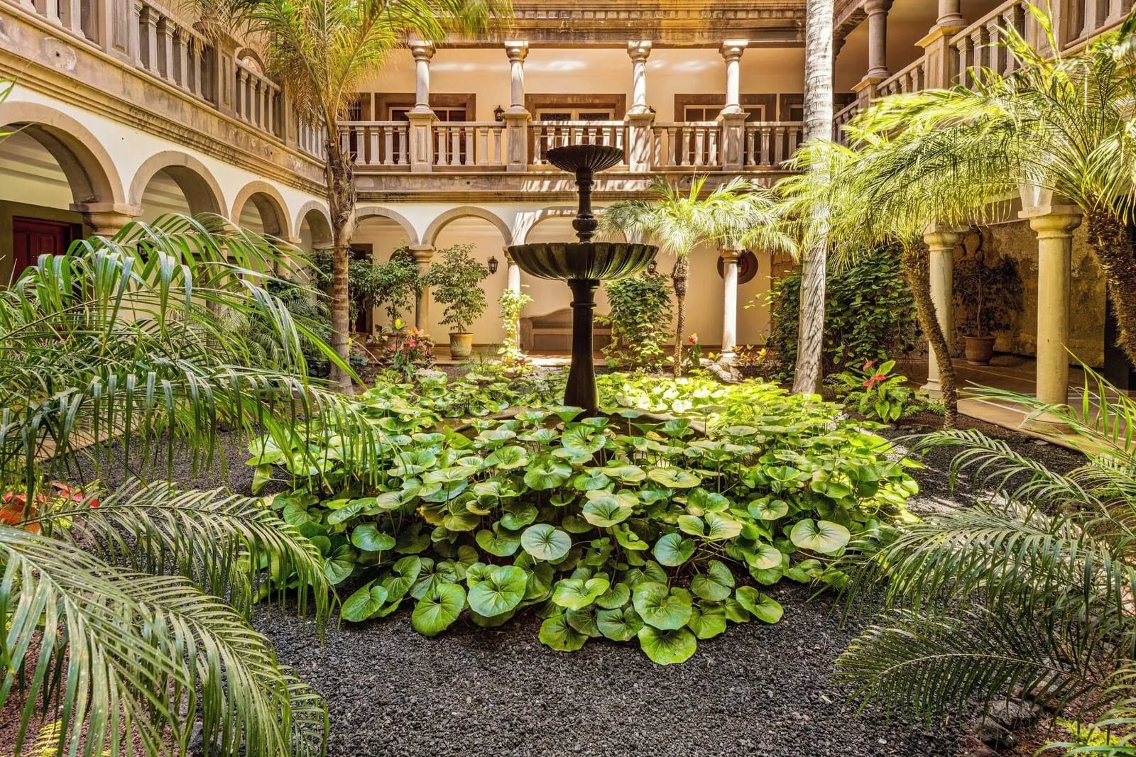 Bahía del Duque: A courtyard with a central fountain surrounded by lush greenery and a multi-level