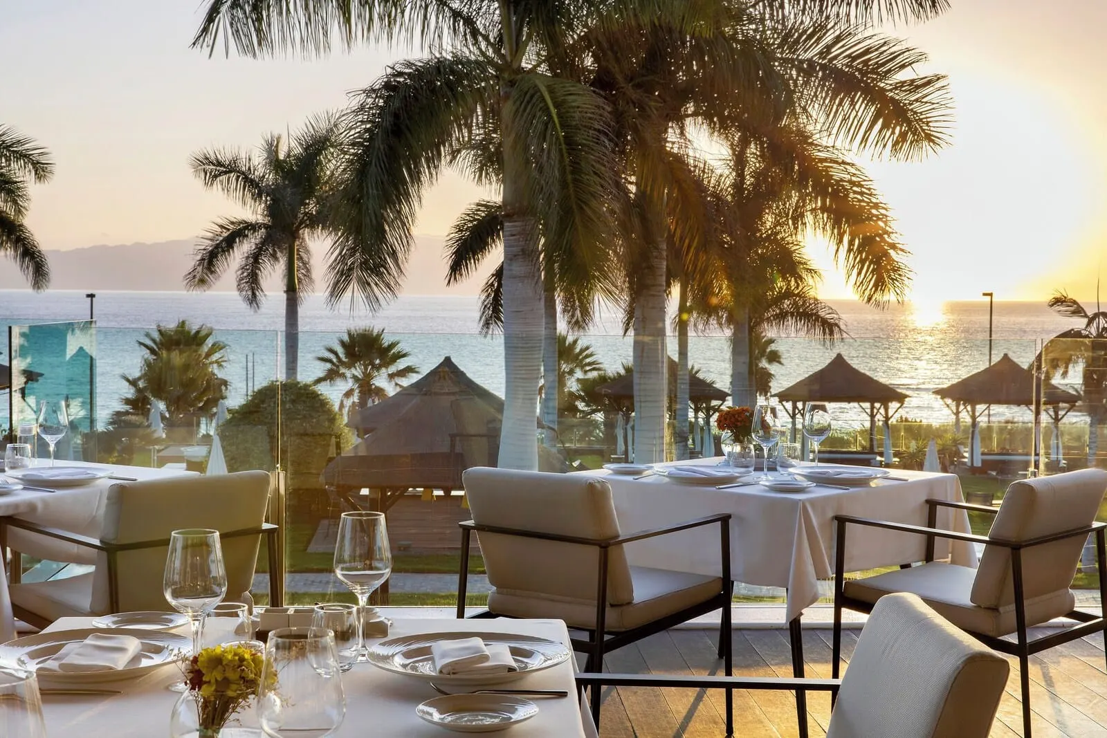 Gran Meliá Palacio de Isora: A table set for dining with a view of the ocean and palm trees