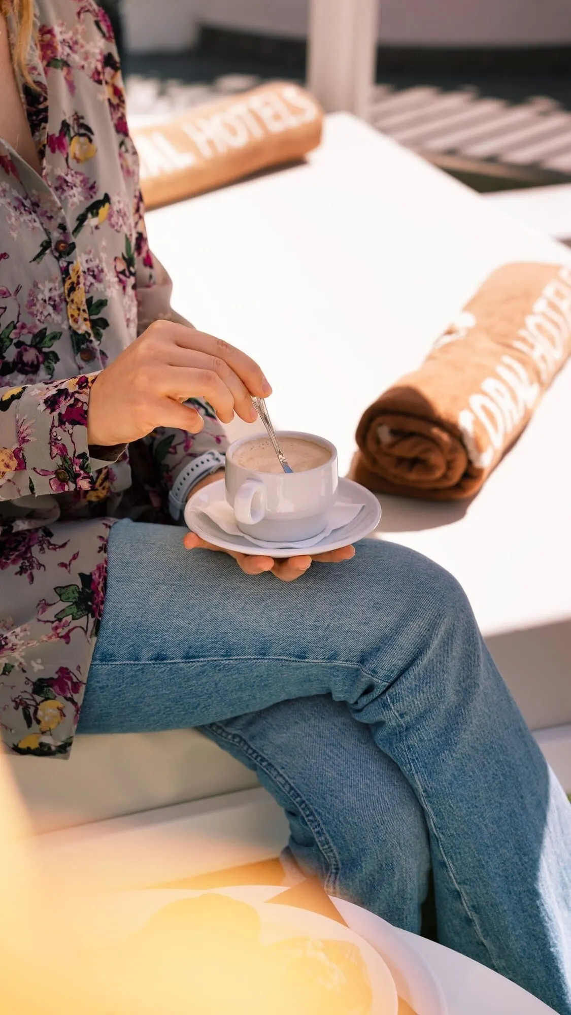 Coral Los Alisios: A person sitting on a white sofa with a cup of coffee on a saucer