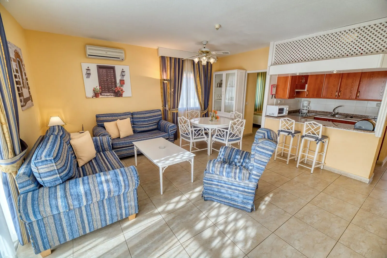 Ona Sueño Azul: A living room with striped sofas, a white coffee table