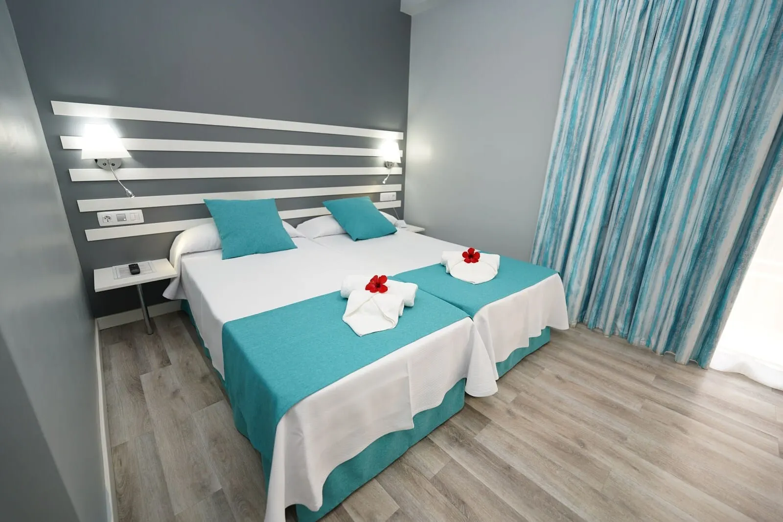 RF Apartamentos Bambi: A modern hotel room with a large bed, a bedside table, and a nightstand