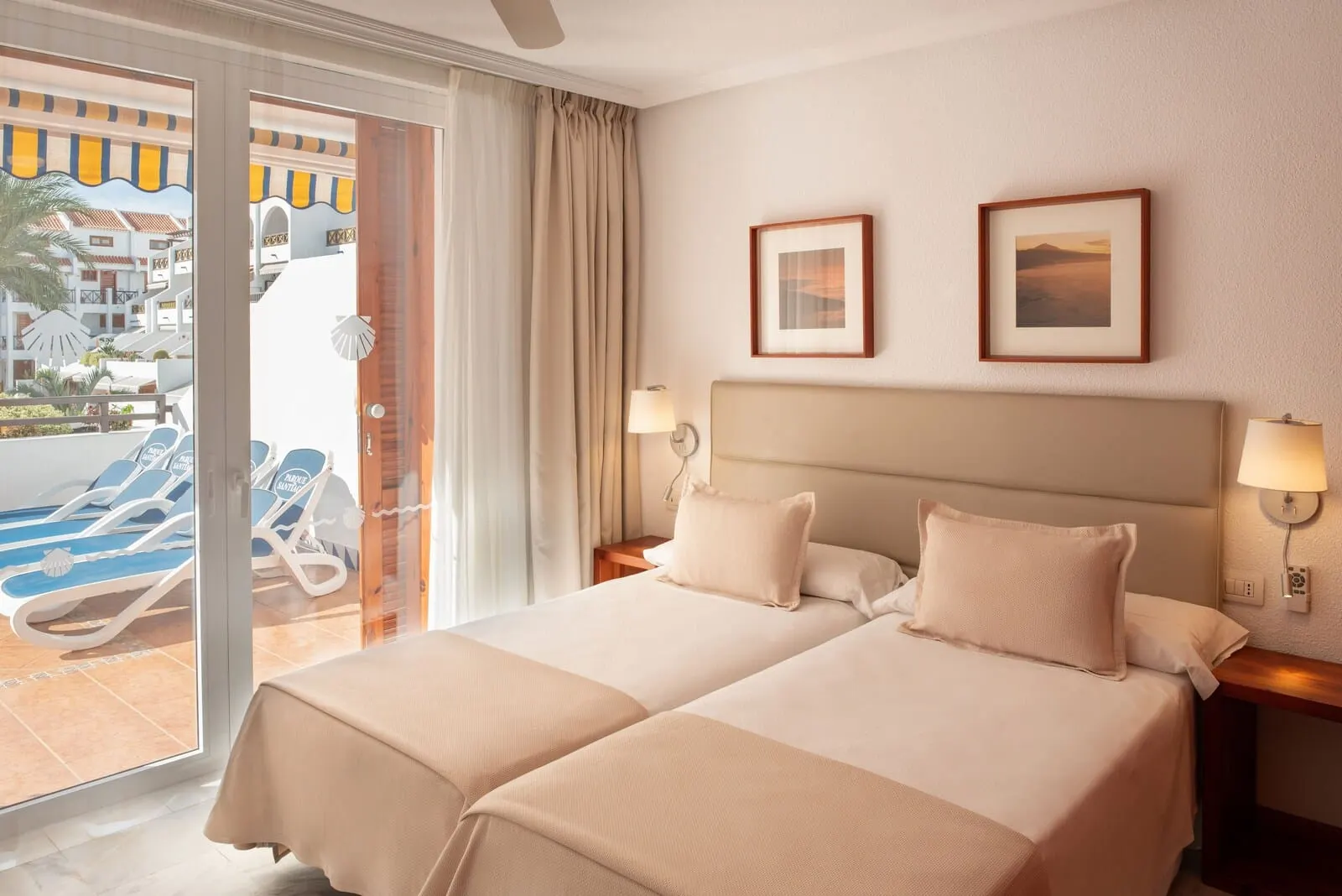 Parque Santiago III: A hotel room with two beds, a balcony with lounge chairs